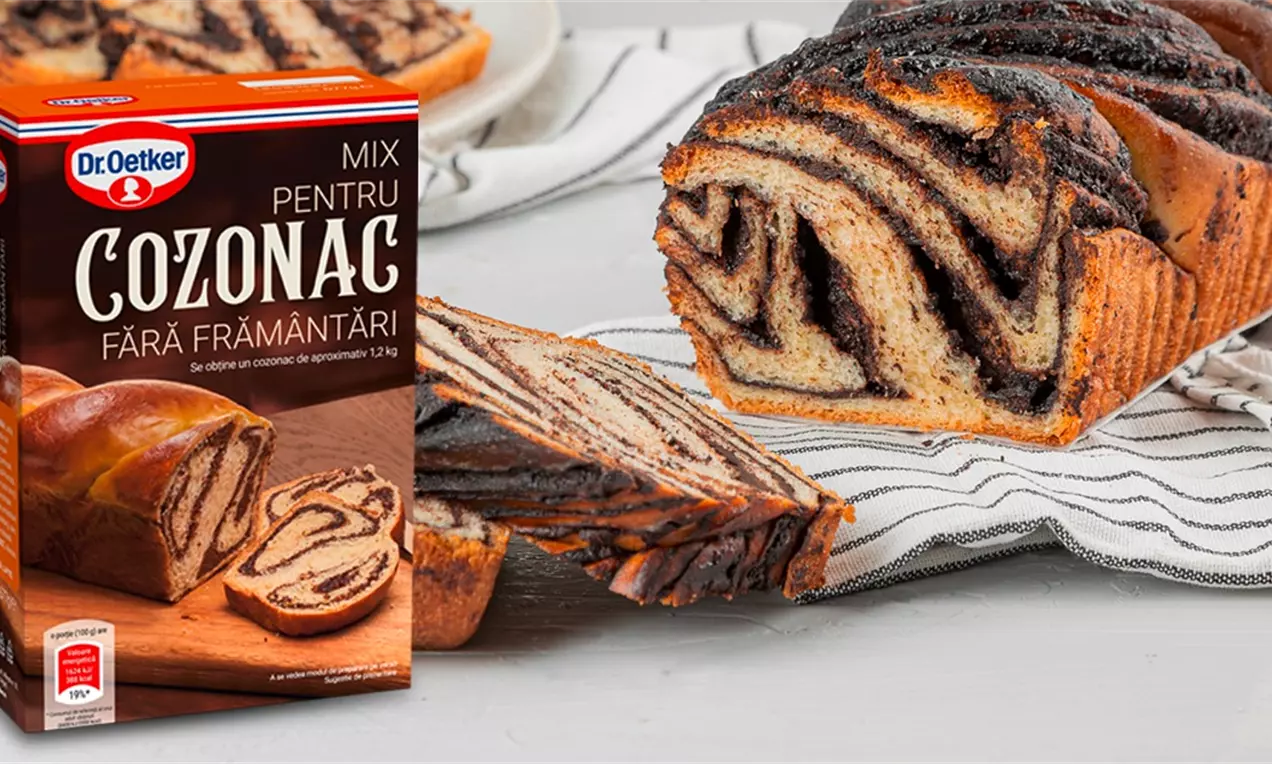 Cozonac auriu cu nucă și ciocolată, cu straturi ondulate și contrast intens, tăiat pe o farfurie și așezat pe un ștergar alb-negru